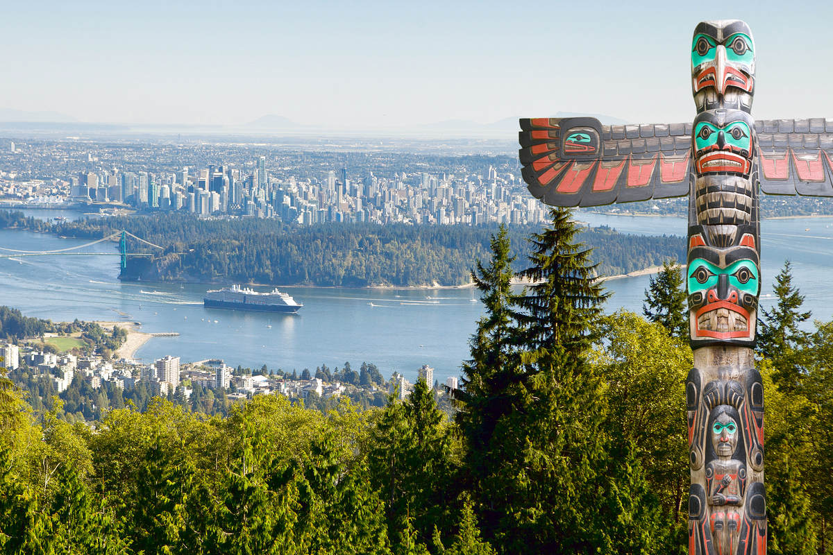 Canadian indigenous communities themed stock photo. Vancouver as seen from viepoint on the road to Cypress bowl. First nation totem pole in the front.
